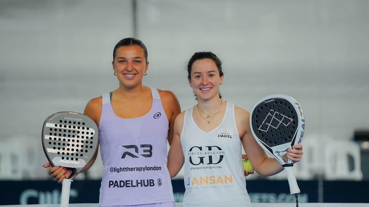 British padel player Catherine Rose smiling and holding a padel racket next to Spain's Lucia Perez Parra