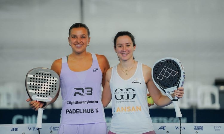 British padel player Catherine Rose smiling and holding a padel racket next to Spain's Lucia Perez Parra