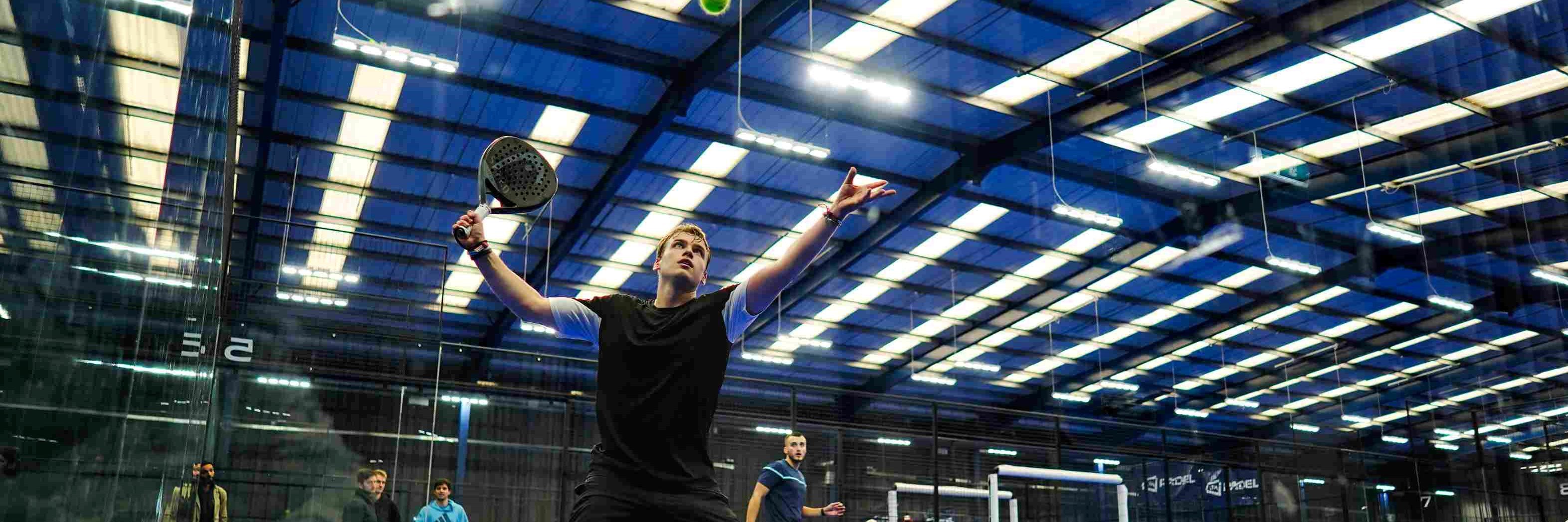 A player hitting the ball off the wall at the LTA Padel British Tour in Derby