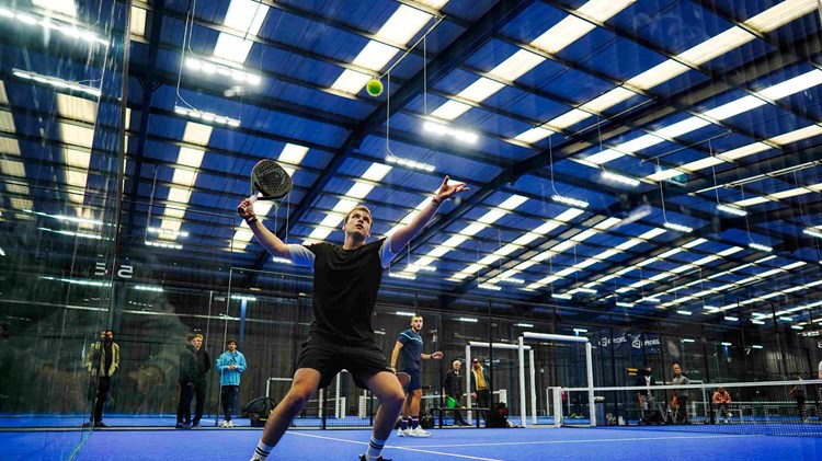 A player hitting the ball off the wall at the LTA Padel British Tour in Derby