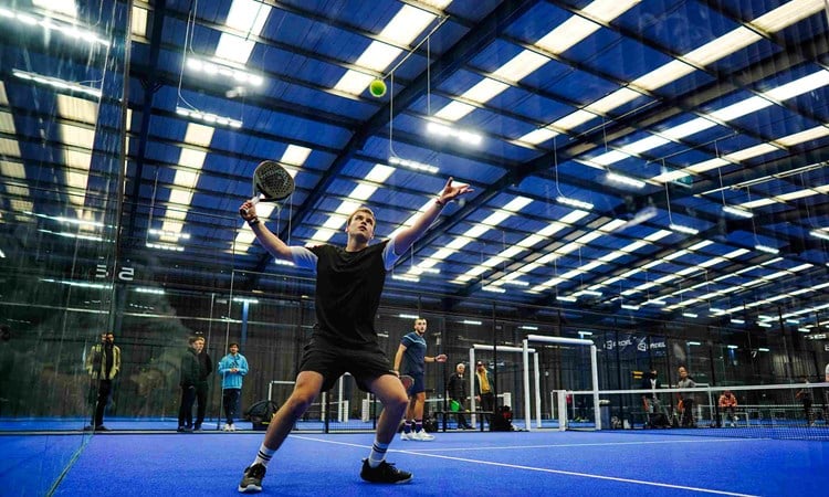 A player hitting the ball off the wall at the LTA Padel British Tour in Derby