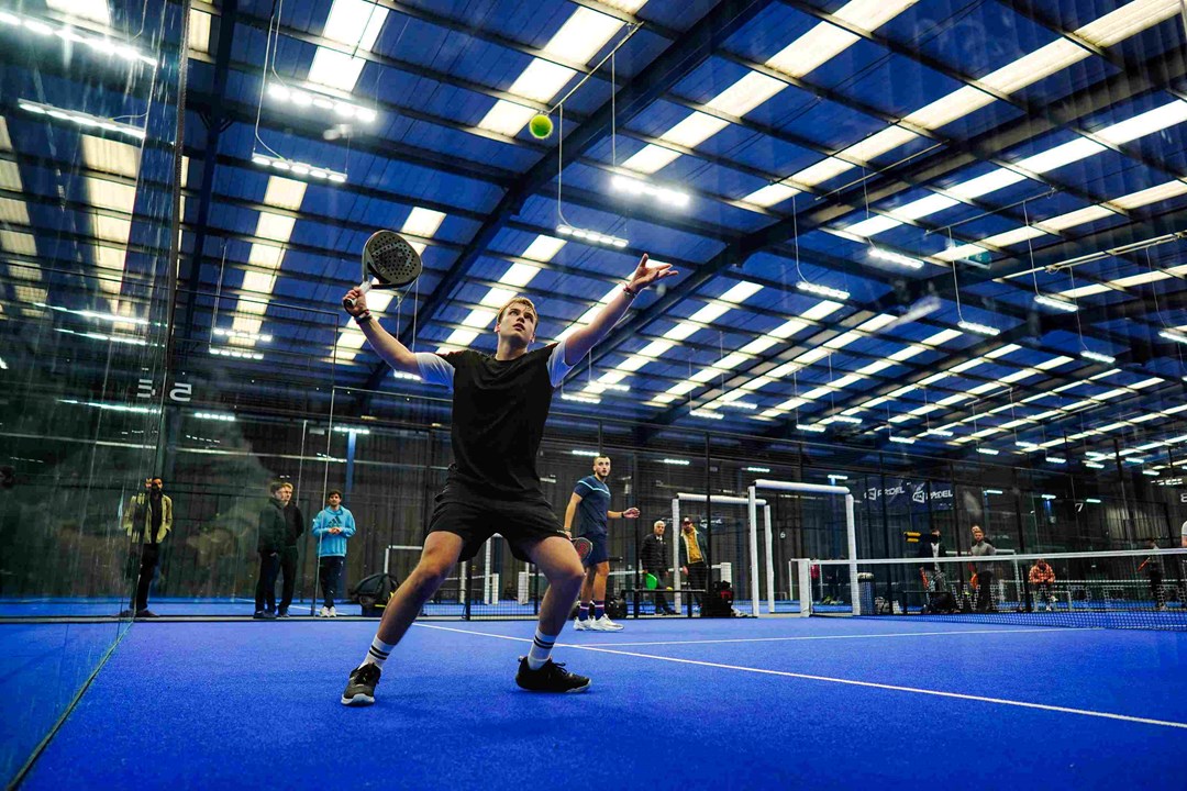 A player hitting the ball off the wall at the LTA Padel British Tour in Derby