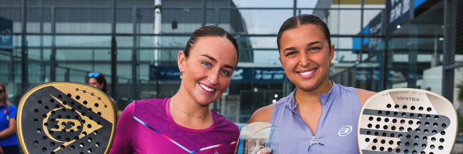 British Padel players Aimee Gibson and Catherine Rose smiling while holding their padel rackets and the FIP Silver Australian Padel Open trophy