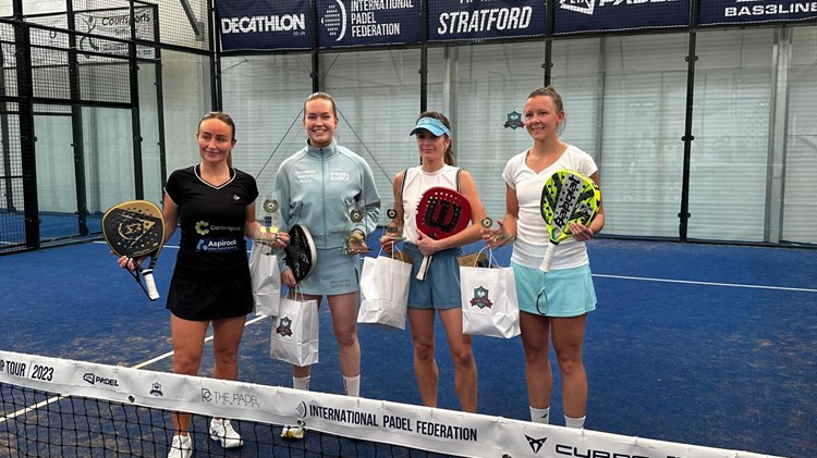 Four female padel players pose for photo with prizes after the  LTA Padel British Tour event in Stratford