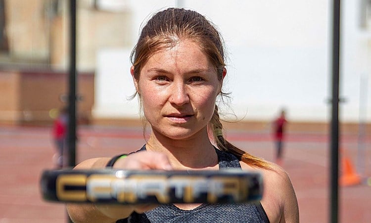 Hansie Ruddick pointing at the camera with her Padel racquet