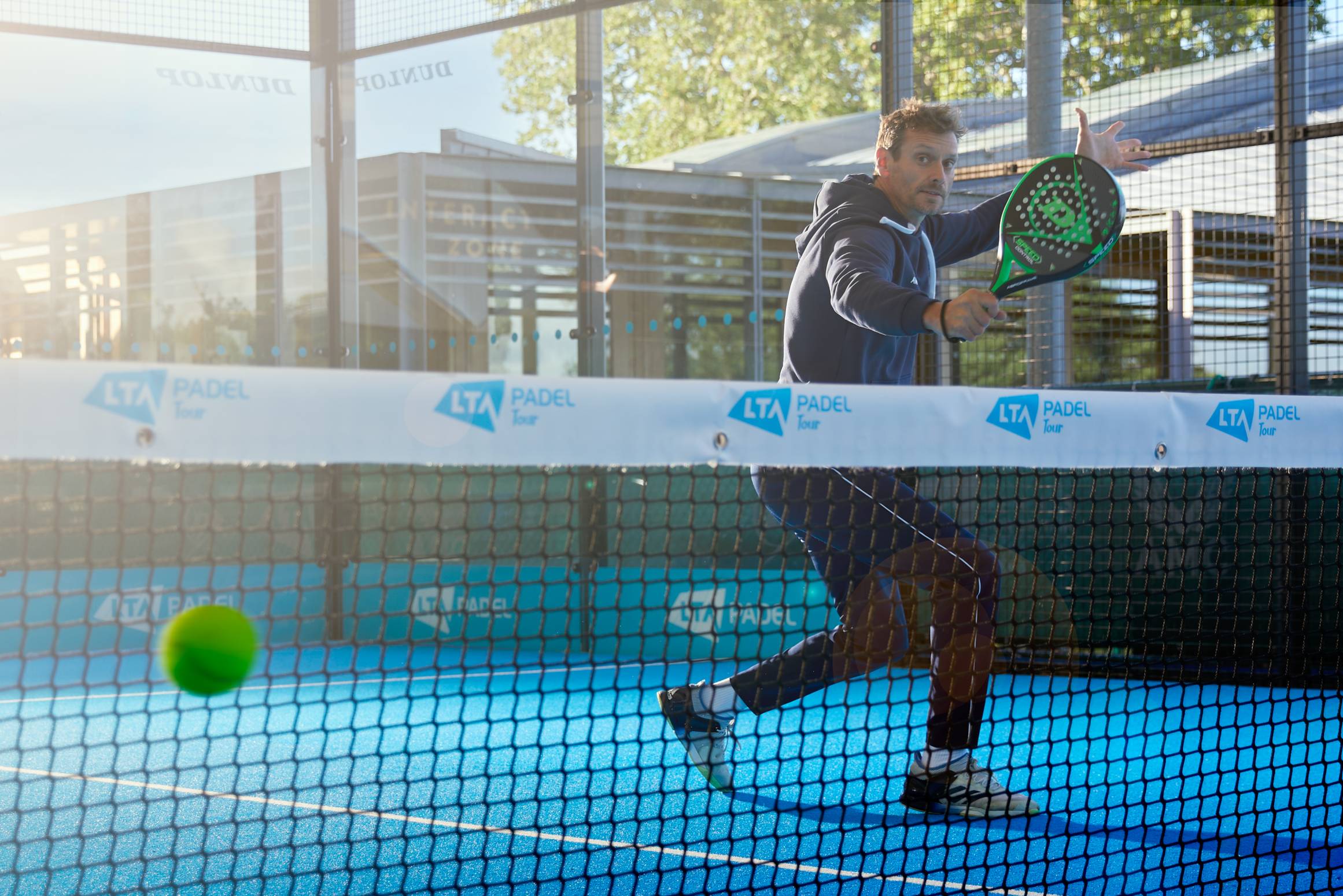 Padel player hitting a compact volley at the net, a technique tennis players transfer easily