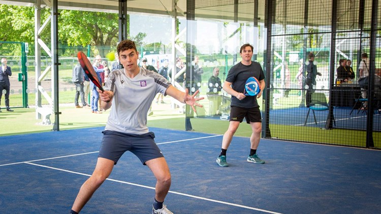 Padel player preparing to hit a volley at the net in the middle of a rally