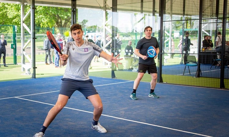 Padel player preparing to hit a volley at the net in the middle of a rally