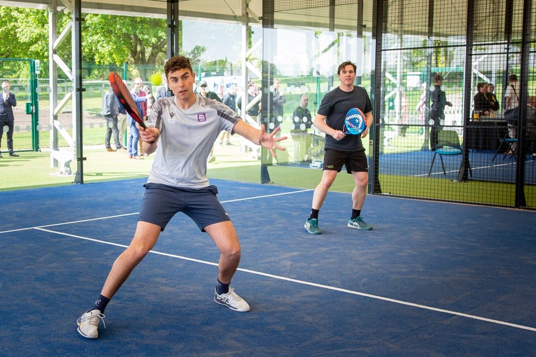 Padel player preparing to hit a volley at the net in the middle of a rally