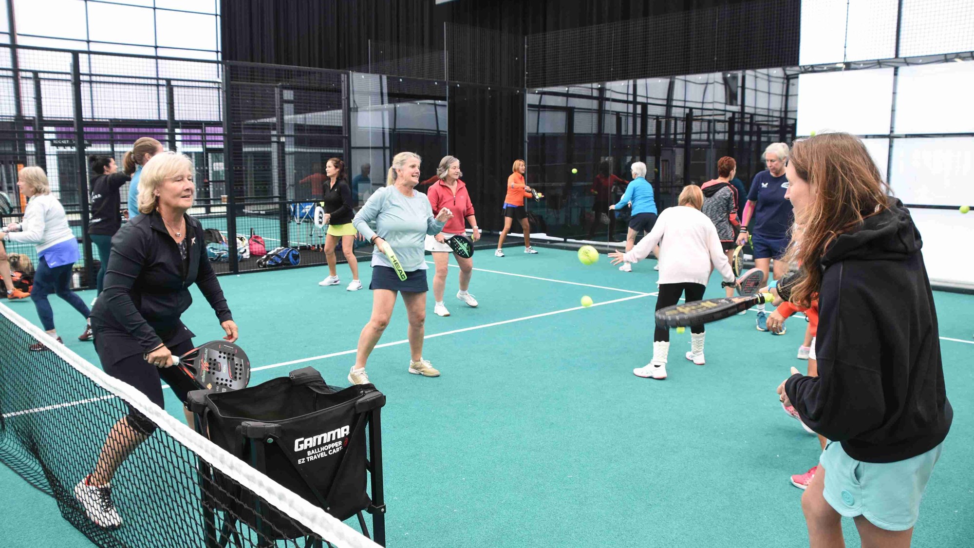 Women taking part in a padel drill on court