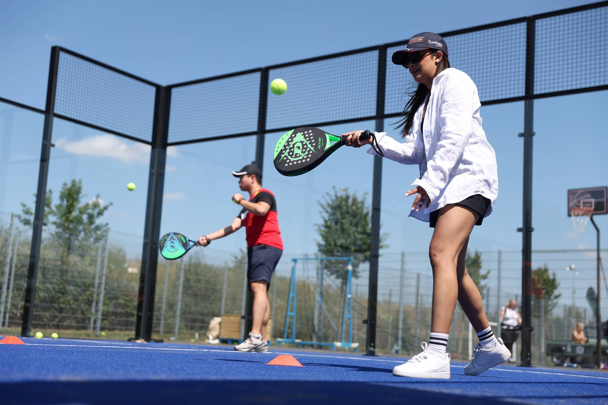 Two players practicing their hits on the padel court