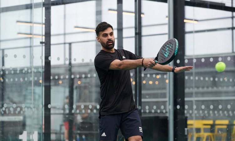 Male padel player lines up a forehand during a rally