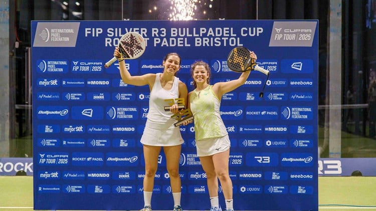 Spanish padel stars Monica Gomez Rivas and Camila Fassio Goyenche holding their padel rackets and trophies in the air after winning the FIP Silver Bristol