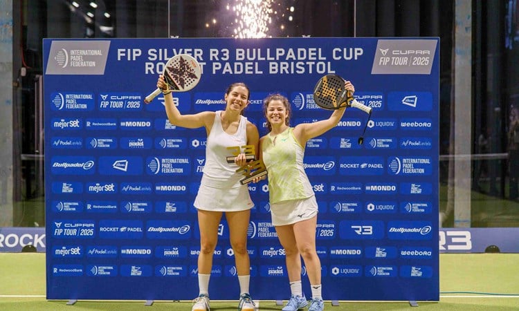 Spanish padel stars Monica Gomez Rivas and Camila Fassio Goyenche holding their padel rackets and trophies in the air after winning the FIP Silver Bristol