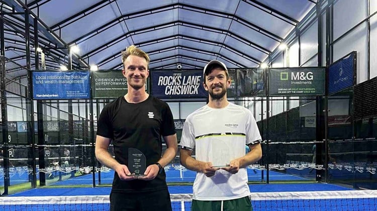 British padel players Nicholas Hatchett and Sam Macneil holding their trophies and smiling on court at the LTA Padel British Tour event at Rocks Lane, Chiswick