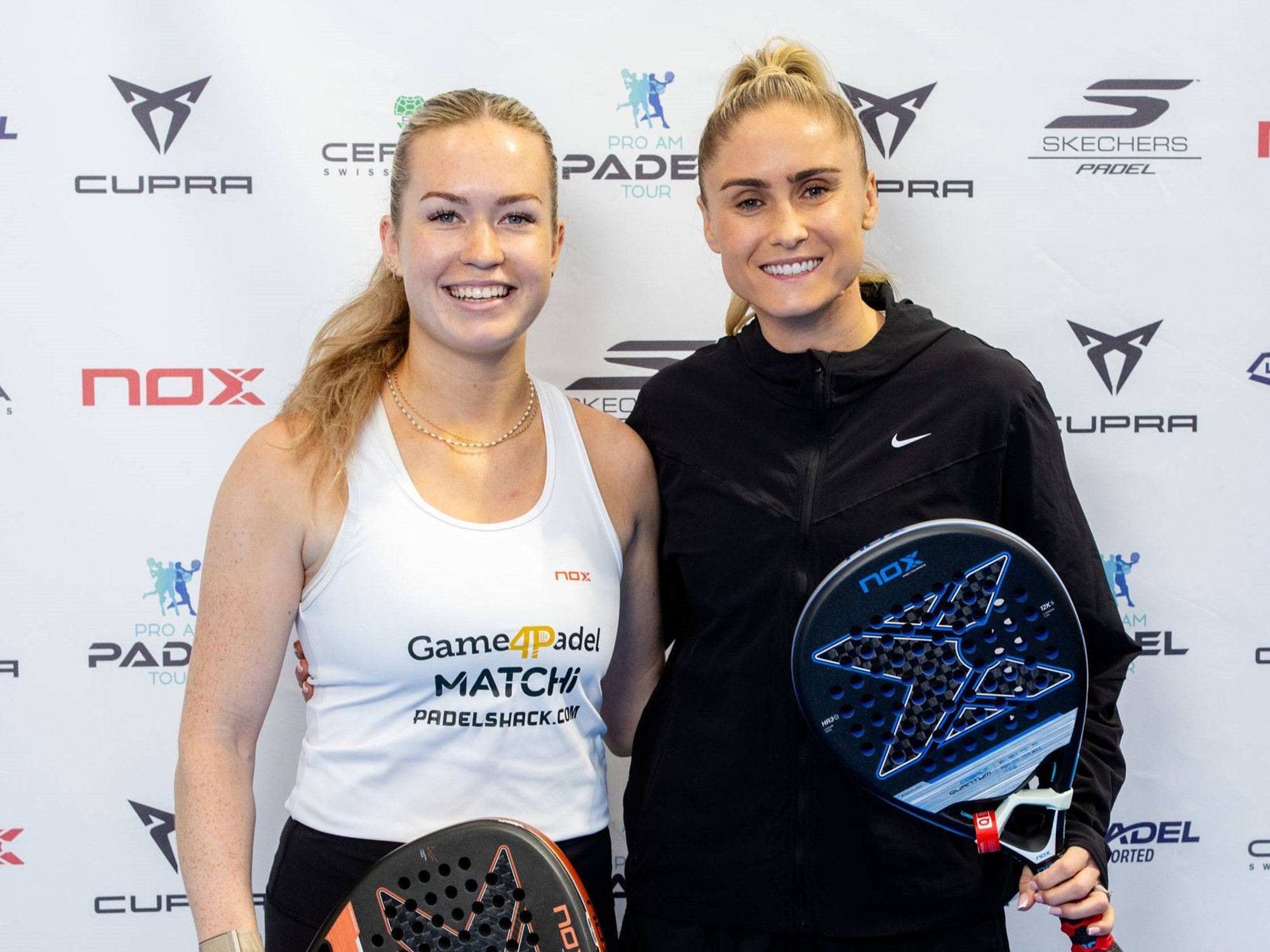 Former Lioness star Steph Houghton stood holding a padel racket and smiling with British No.3 Tia Norton at the Pro Am Padel Tour event at Pure Padel Stockport