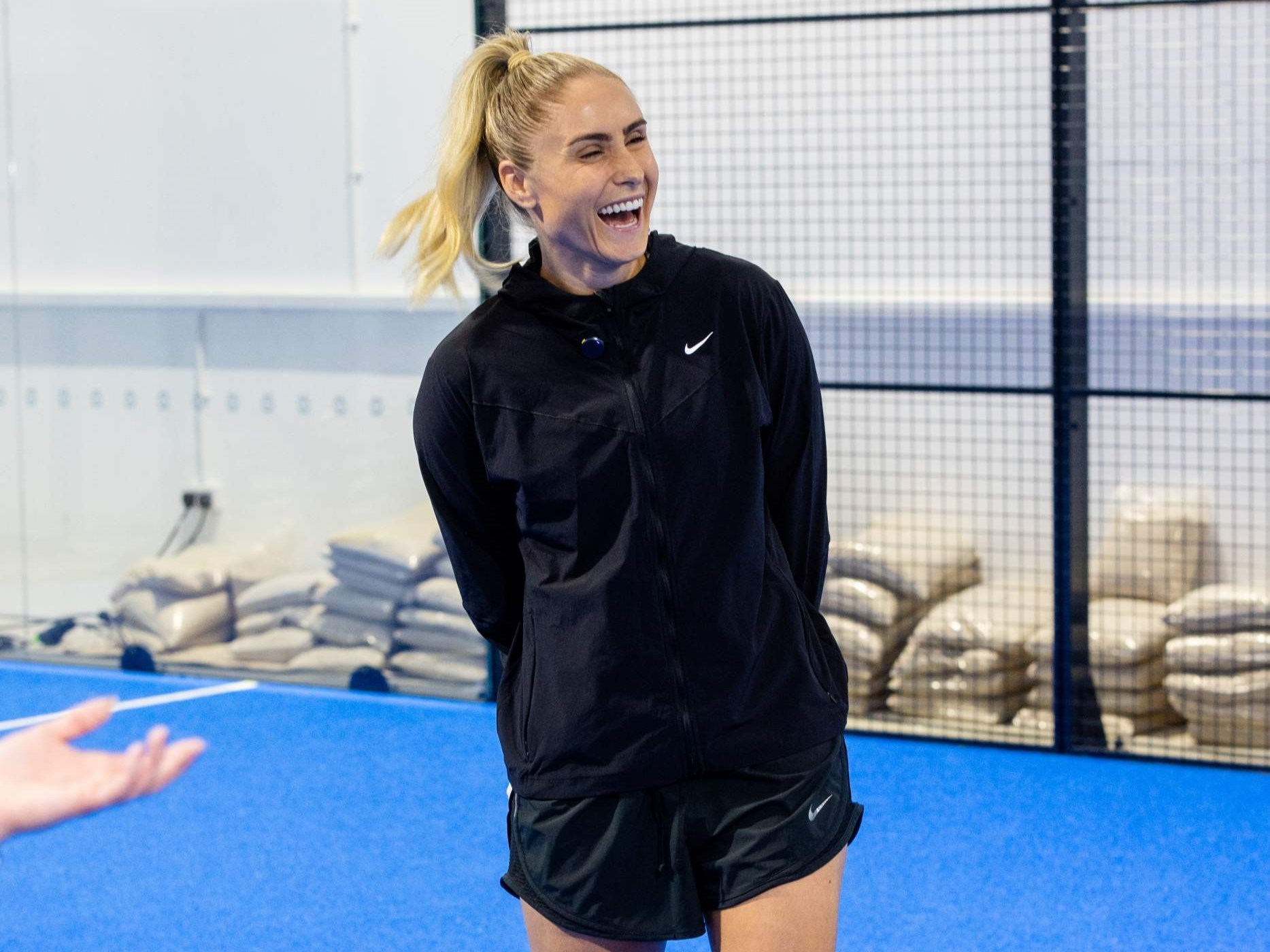 Former Lioness star Steph Houghton smiling and laughing on a padel court at the Pro Am Padel Tour event at Pure Padel Stockport