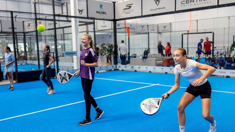 Two girls laughing while playing padel at a Pro Am Padel Tour community event