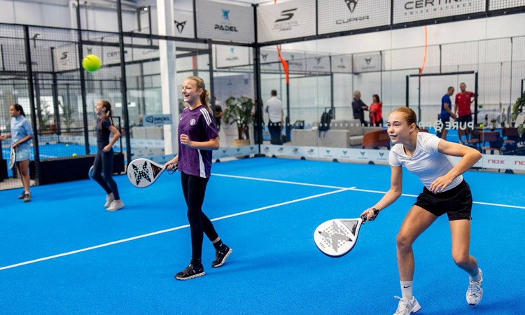 Two girls laughing while playing padel at a Pro Am Padel Tour community event