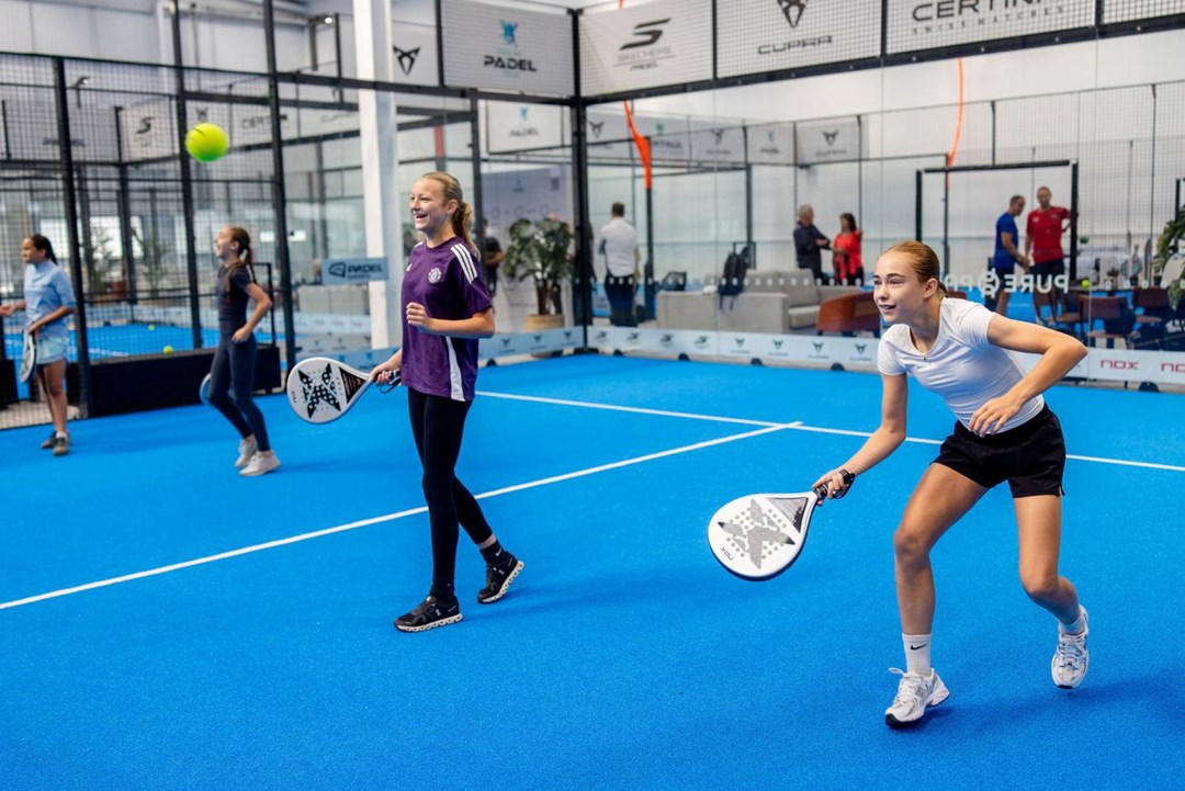 Two girls laughing while playing padel at a Pro Am Padel Tour community event