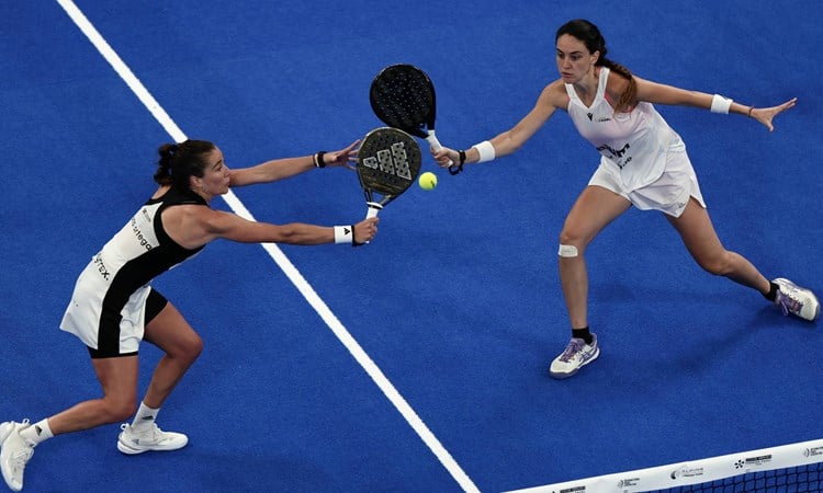 Two women's players reaching for a volley in the Premier Padel Tour