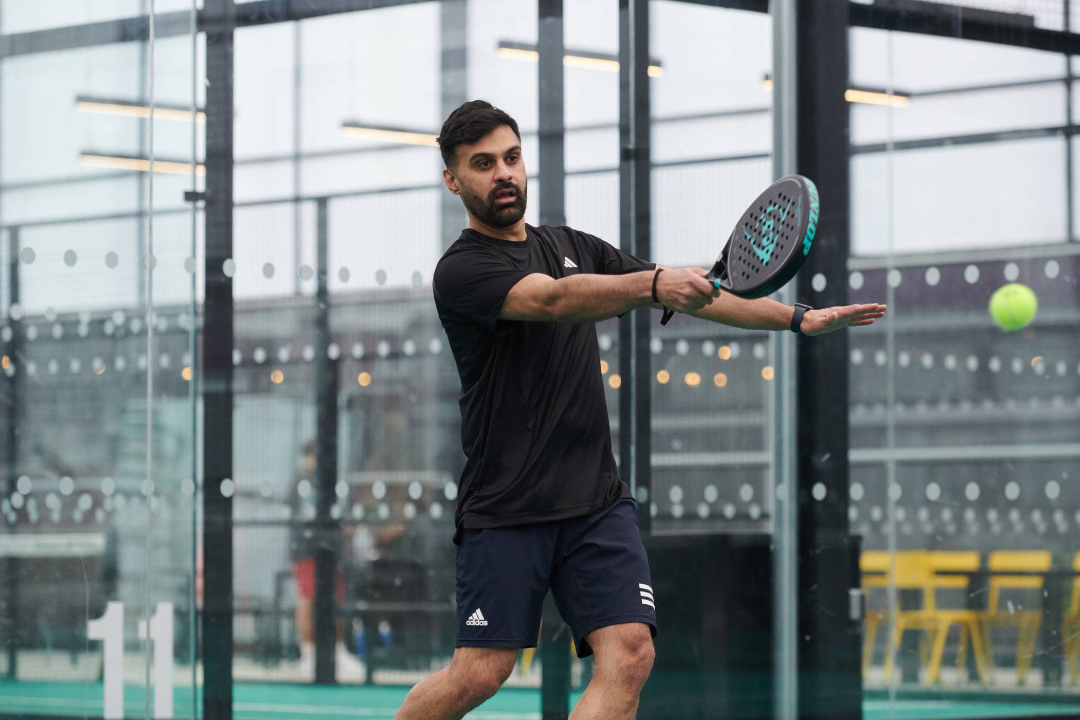 Male padel player lines up a forehand during a rally