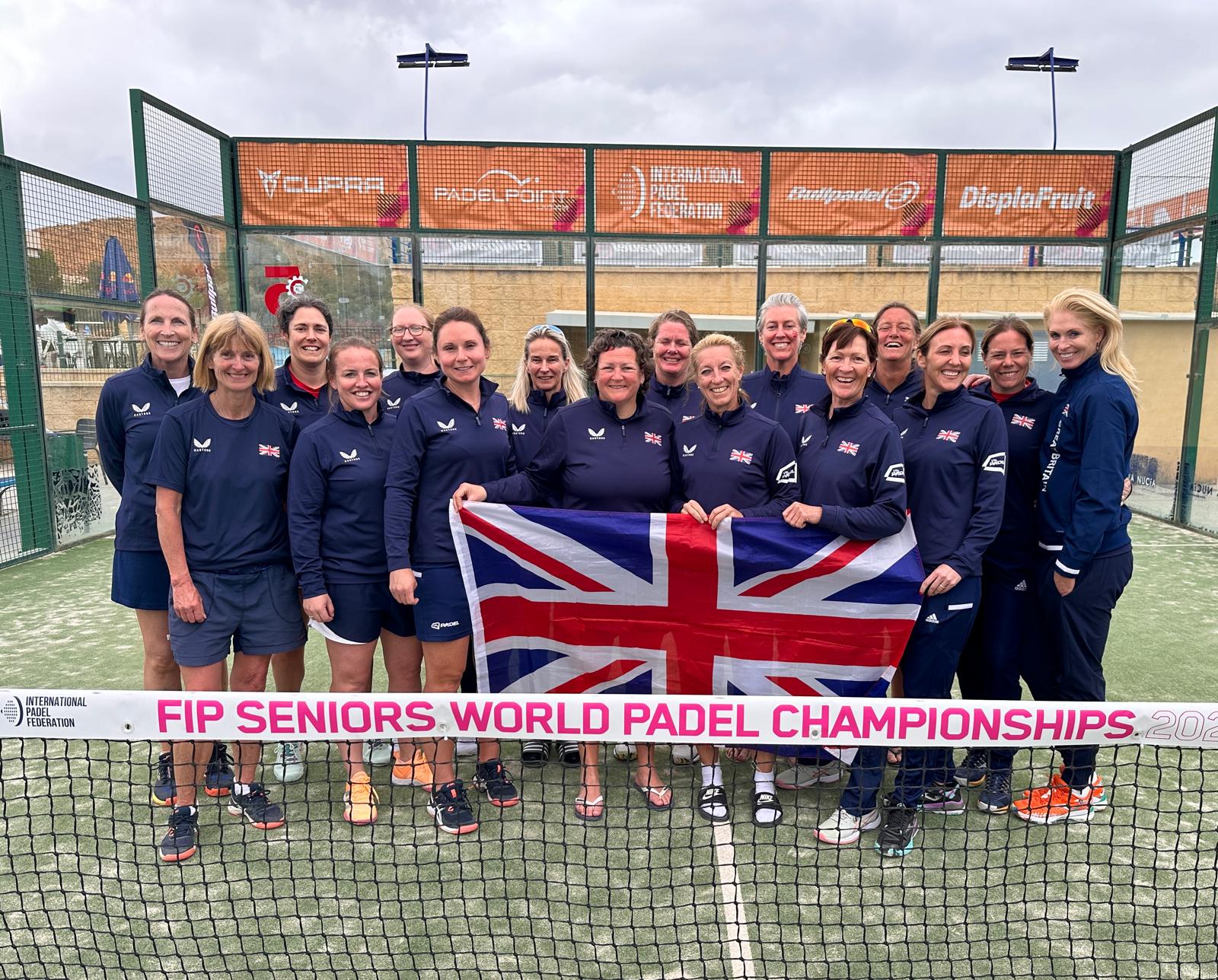 GB Senior Women's Padel team post for photo with the United Kingdom flag on a padel court