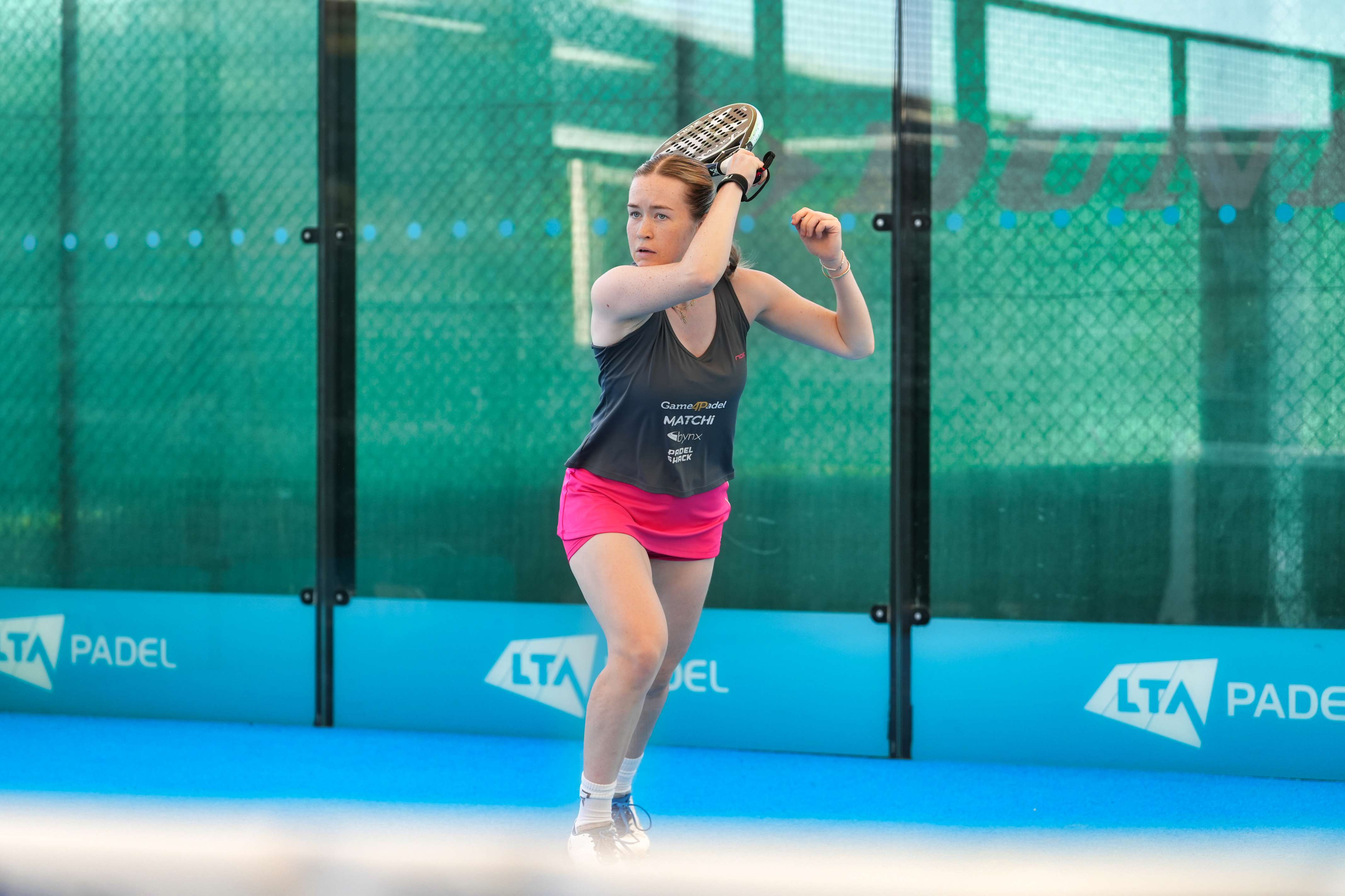 Tia Norton hits a forehand shot on a padel court at the National Tennis Centre