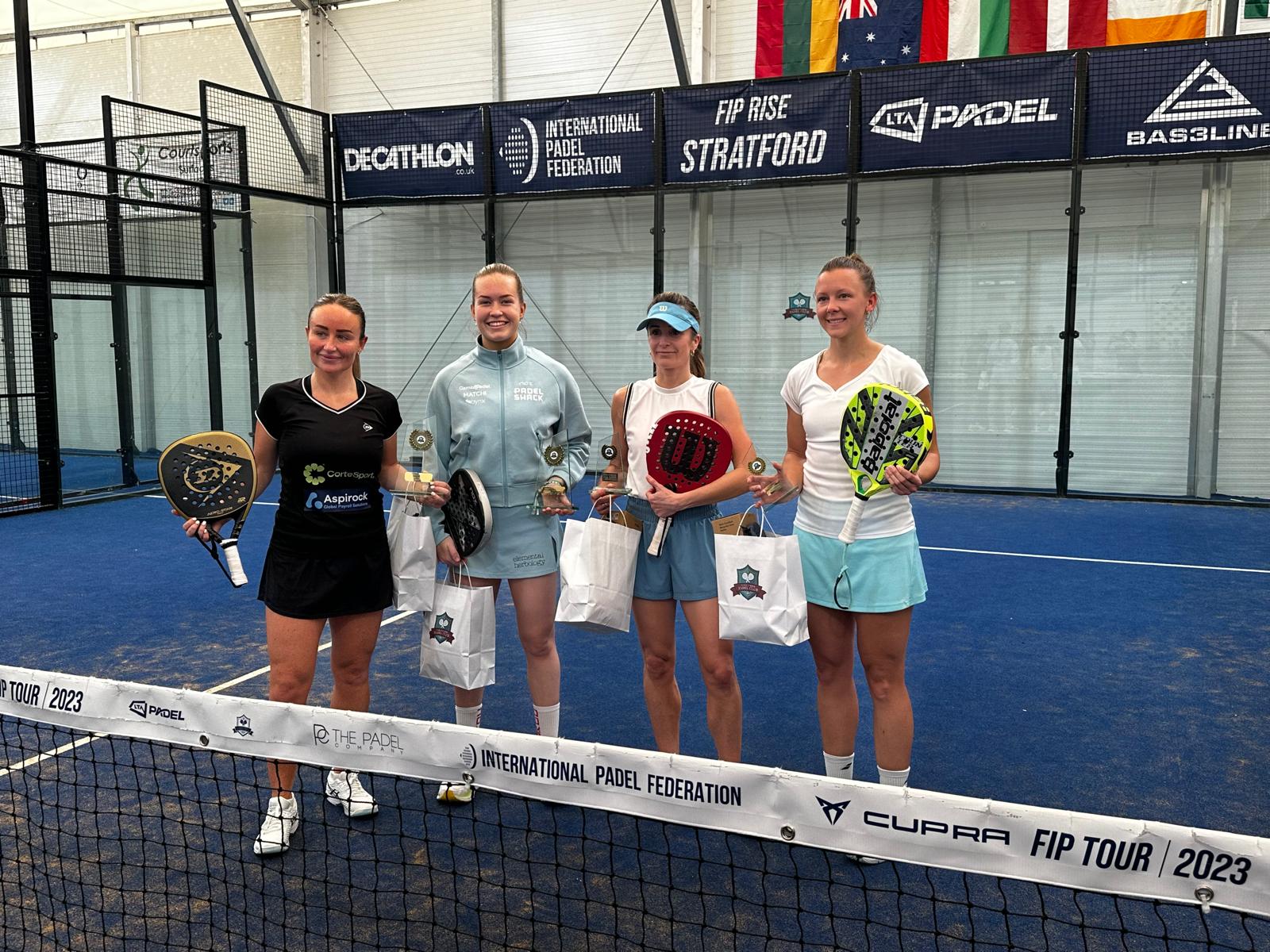 Four female padel players pose for photo with prizes after the  LTA Padel British Tour event in Stratford