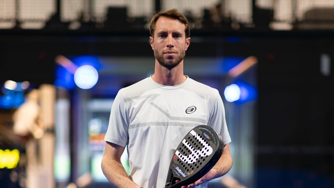 Chris Salisbury holding his padel racket and smiling on court