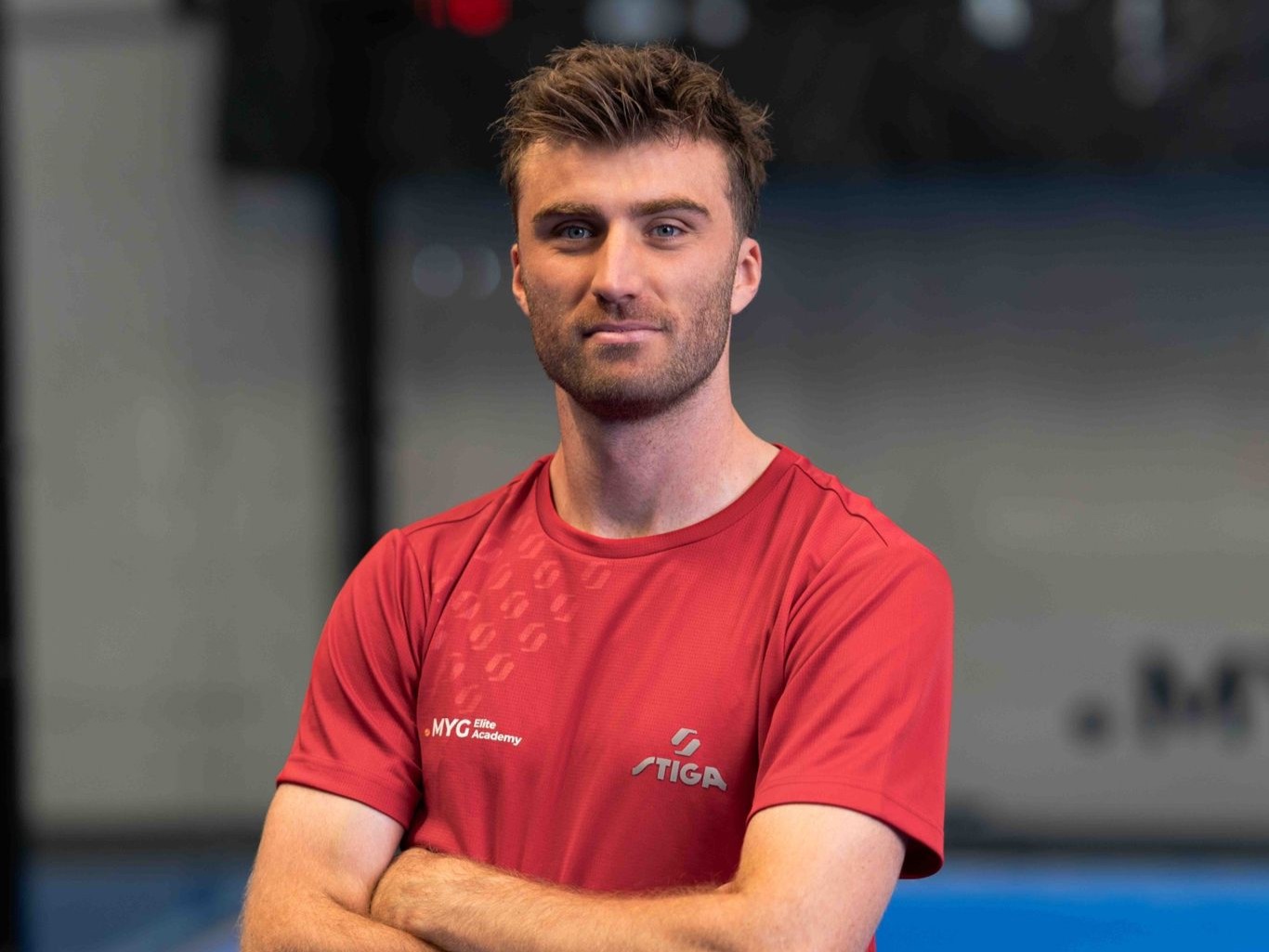 British padel player staring at the camera while crossing his arms