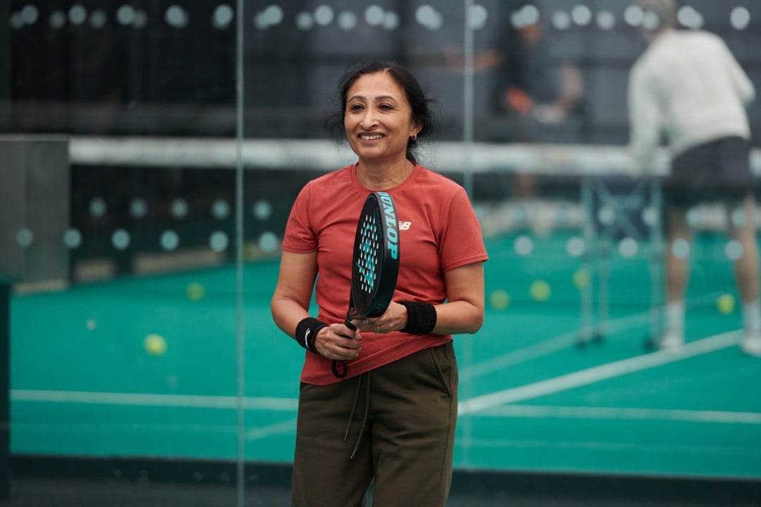 Woman holding padel racket on court